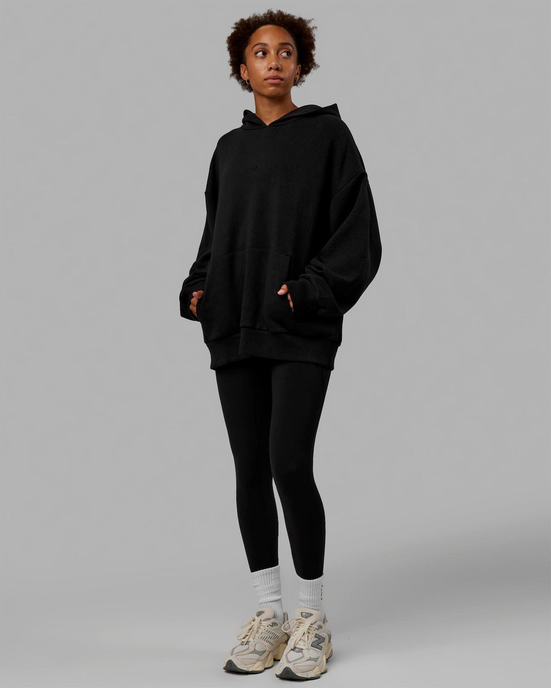 Woman wearing Unisex MVP Hoodie Oversize - Black